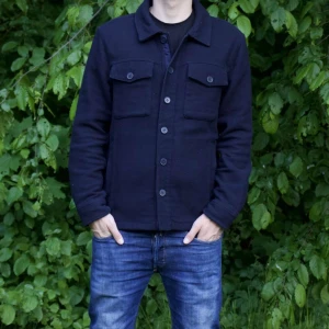 Mörkblå overshirt - Stilren blå overshirt från Cubus med klassisk krage och knäppning framtill. Jackan har två stora bröstfickor med lock och knappar, samt raka ärmar. Perfekt för lager-på-lager och enkel att matcha med jeans.
