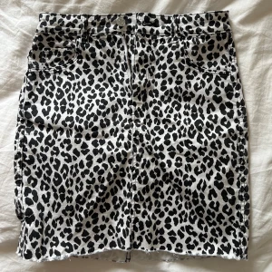 Leopardmönstrad kjol från H&M - Säljer en snygg leopardmönstrad kjol från H&M. Kjolen är kort, har klassisk femficksdesign och stängs med dragkedja och knapp framtill.