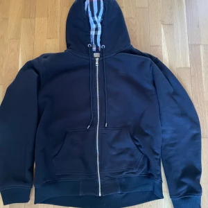 Svart burberry zip up hoodie - Tänkte sälja min burberry zip up hoodie eftersom den har blivit för stor på mig. Den är i nyskick, storlek XXL men passar perfekt på dig som har XL och även L men kanske lite lös.
