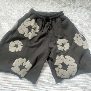 Svarta shorts med gråa blommor från denim tears - Unika svarta shorts från Denim Tears med stora gråa blommor perfekta till sommaren helt oanvända med lappar kvar 