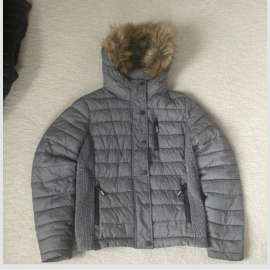 Grå quiltad dunjacka med fuskpäls