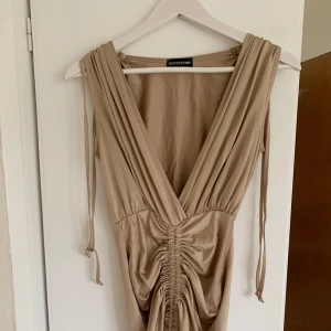 Klänning - Prettylittlething klänning i strl Xs/S. Fin använd 1 gång. Justerbar scrunch beroende på önskad längd och passform💛
