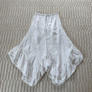 Vit långkjol med broderi - Superfin vit långkjol från La Cotonnière med volangkant och broderade detaljer. Kjolen har snörning i midjan och är gjord i mjuk bomull. Storlek 36/S, men har resår i midjan vilket gör att den även passar mig som har M