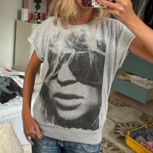 Grå loose-fit t-shirt med tryck - Snygg grå t-shirt i loose-fit modell med korta ärmar och svart tryck framtill. T-shirten har rund halsringning och är tillverkad i mjukt material som känns skönt mot huden. Perfekt för en avslappnad och cool stil.