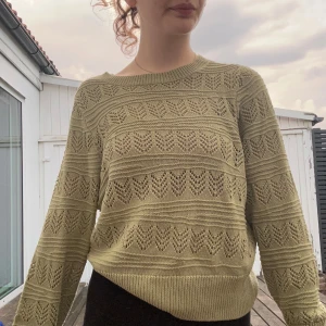 Olivgrön stickad tröja med hålmönster - En skön stickad tröja som funkar både som coverup men också kläs upp. Funkar som både vardaglig och festlig!