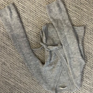 Grå omlottkofta från Gina Tricot XS - Mysig grå omlottkofta från Gina Tricot i stickad kvalitet. Koftan har långa ärmar, ribbade muddar och knytband i midjan för en snygg passform. Perfekt att slänga på sig när det är lite kyligt ute.