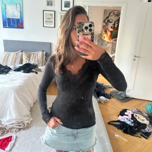 Svart långärmad tröja från intimisssmi❣️ - Svart långärmad blus med v-ringning och fina spetsdetaljer vid halsringning och ärmslut. Sitter tight och passar perfekt till jeans eller kjol. Så mjuk och stretchig, passar därav flera storlekar. Inga defekter och enbart använd ett fåtal gånger!💕