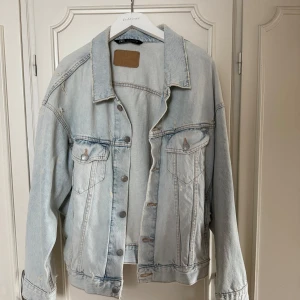 Ljusblå oversized jeansjacka från Zara - Säljer en ljusblå jeansjacka från Zara i storlek L. Perfekt att slänga över en hoodie eller t-shirt för en chill look. Använts 1 gång