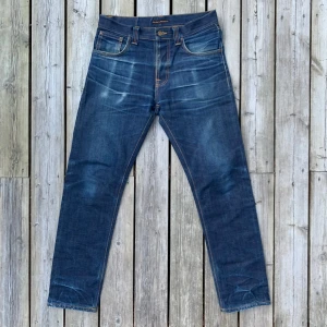 Sjukt Snygga Nudie Jeans med Fades - Säljer dessa otroliga nudie jeans i storlek 31/32. Rak modell. Modellen heter Steady Eddie (Inte den nuvarande med en 2a i namnet utan den originella som är inköpt för 8 år sedan). Var ursprungligen raw denim (inte selvedge) och har använts vid färre tillfällen under omkring 3 år. Otroligt fint skick, En byxa som bara blir snyggare ju mer du använder den 🚀. Midjan är 42 cm och totala längden 105-106 cm. Vänligen observera att måtten kan skilja minimalt. Hör gärna av er🙌