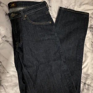 Mörkblå raka jeans från Lee - Säljer ett par mörkblå jeans från Lee i modellen Daren Zip Fly. De har rak passform och stängs med dragkedja. Storlek 29 i midjan och 32 i längd.