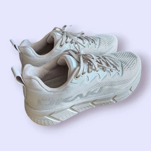 Lätta träningsskor från OKAKI - Snygga sneakers från OKAKI med chunky platt sula och ventilerande meshdetaljer. Skorna har snörning, diskret logga på sidan och dragflik bak. Perfekta för dig som gillar stilrena och sportiga vibes. Fjäderlätta och perfekta springskor. Näst intill oanvända. Nypris: 1300 kr.