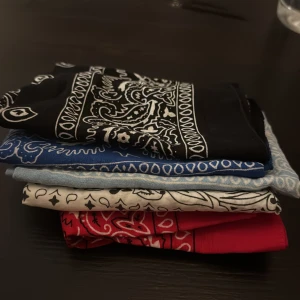 Färgglada bandanas i paisleymönster - Säljer ett gäng bandanas i svart, blått, vitt och rött med klassiskt paisleymönster. Perfekt accessoar för att lyfta din stil, knyt runt halsen eller i håret. Tunt och mjukt material som känns skönt mot huden. Alla 5 för 90kr