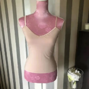 Rosa linnetopp med smala axelband - Säljer en enkel och stilren rosa linnetopp med smala axelband och v-ringning. Toppen är figurnära och har en clean look som passar perfekt till jeans eller kjol. Materialet känns mjukt och stretchigt, vilket gör den superbekväm att bära.