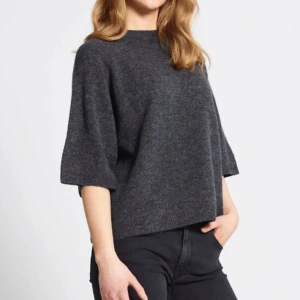 Mörkgrå stickad tröja med trekvartsärm - Mörkgrå stickad tröja som är t ett ätt stor i storleken. Perfekt för lager-på-lager och enkel att matcha med jeans eller kjol. Använd några få gånger. Säljs nytvättad. Original pris: 150kr