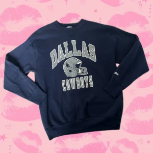 Dallas Cowboys sweatshirt från Bike XL - Mörkblå vintage Dallas cowboys NFL sweatshirt med Dallas Cowboys-tryck och hjälm på bröstet. Crewneck-modell med långa ärmar och ribbade muddar. Tillverkad i 50% bomull och 50% polyester, perfekt för dig som gillar amerikansk sportstil.
