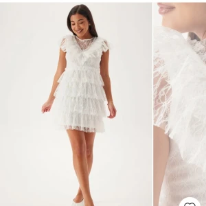 Vit spetsklänning med volanger - Säljer denna klänningen som är perfekt nu till studenten! Aldrig använd, bara testad. Lapp sitter kvar! 