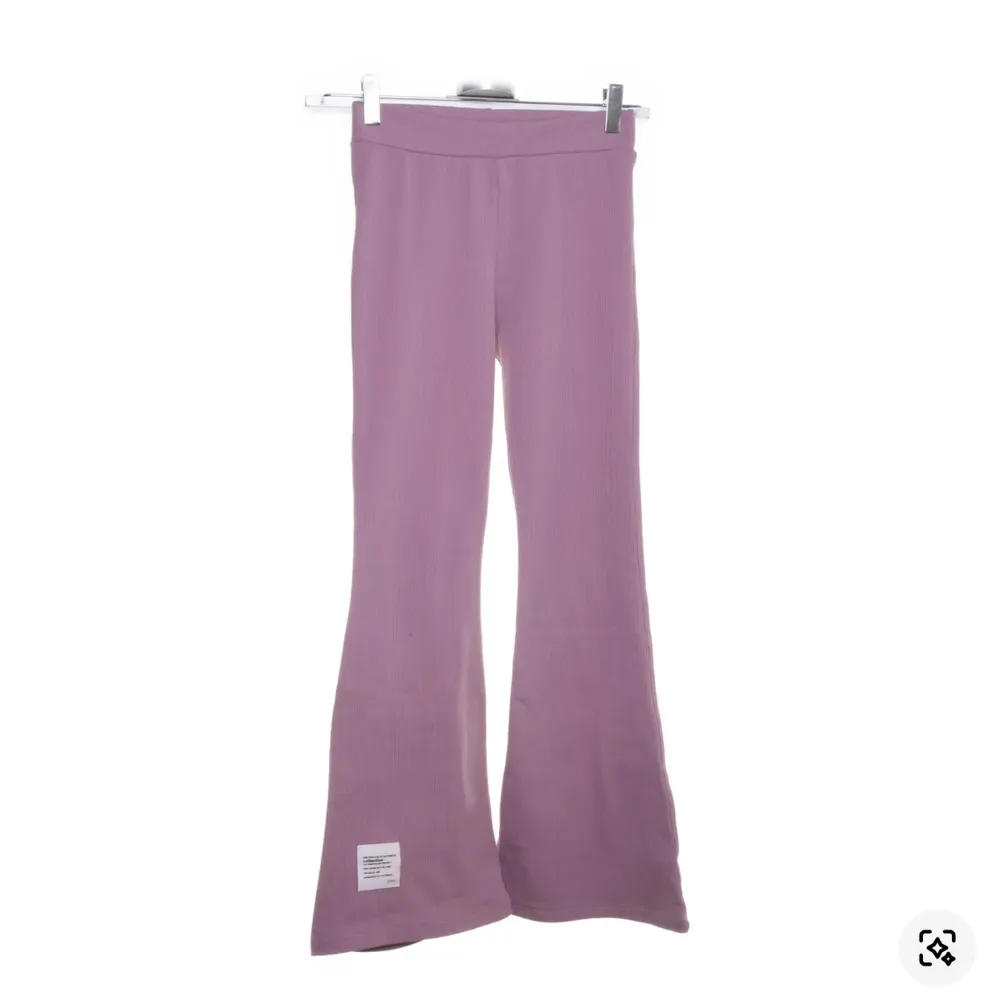 Snygga rosa byxor från Viollen med en ribbad struktur. Byxorna har en bootcut-stil som ger en trendig look. Perfekta för att lägga till lite färg i garderoben. De passar nog någon i längden 160. Tyvärr för korta för mig🥰. Farkut & Housut.