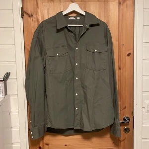 Grön skjorta/tunn overshirt från Dobber - Säljer en snygg grön skjorta/tunn overshirt från Dobber i storlek L.