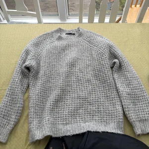 Grå stickad tröja från Lager 157 - Säljer en stilren grå stickad tröja från Lager 157. Tröjan har en klassisk rund hals och långa ärmar, perfekt för kyligare dagar. Den har en texturerad stickning som ger en extra dimension till looken. Passar utmärkt till både jeans och chinos. Älskar!!!💕💕💕🌸🌸🌸