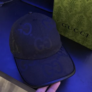 Svart keps från Gucci - Snygg svart keps från Gucci med det ikoniska GG-mönstret. Kepsen har en justerbar rem baktill och är tillverkad i ett slitstarkt material. Perfekt för att ge din outfit en lyxig touch.