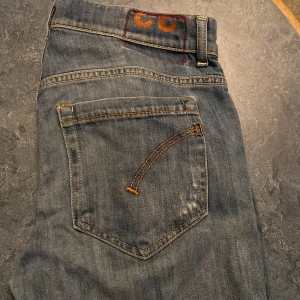 Dondup slim fit W30 - Snygga blå jeansbyxor med en unik broderad detalj på bakfickan. Byxorna har en klassisk femficksdesign och är perfekta för en avslappnad stil. De har en slim passform. Längden är 95 cm och jag skulle säga att de passar mellan 165-180cm