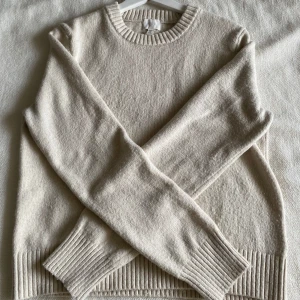 Beige stickad tröja M - Säljer en stilren beige stickad tröja i storlek M med rund hals och långa ärmar. Tröjan har ribbade muddar vid ärmslut och nederkant. Den har använts väldigt få gånger och har inga defekter❣️