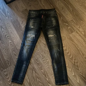 Svarta jeans från Dsquared2 - Snygga svarta jeans från Dsquared2 med slitna detaljer och en cool tvätt. De har en straight passform och är perfekta för en trendig look. Märkeslappen på baksidan ger en extra touch av stil.