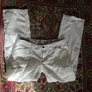 lågmidjad esprit byxor - Snygga lågmidjad vita bootcutbyxor med flera fickor och knappdetaljer från esprit, ser lite ut som linnebyxor                                                       Midjemått rakt av: 40cm innerbenlängd: 79 cm