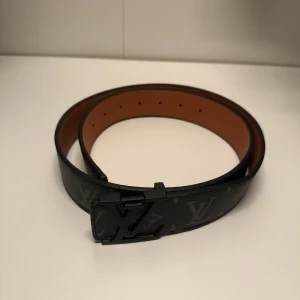 Svart Louis Vuitton bälte - Louis Vuitton bälte med svart emblem som ger detta bälte en riktigt stilren look. Använd några gånger men väldigt bra skick. Pris kan diskuteras vid snabb affär. Har även ett likadant bälte fast 105cm och med silvrigt emblem så om intresserad skicka dm. Vid minsta lilla fundering tveka inte på att skicka iväg ett meddelande