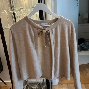 Beige tröja med knyt - Säljer en mysig tröja i beige med knyt framtill. Använd ca 2gånger 
