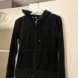 Svart hoodie i sammet - Säljer en svart hoodie i mjukt sammetstyg med dragkedja och huva. Hör av er vid funderingar eller om ni vill ha bilder med hur plagget sitter på mig.