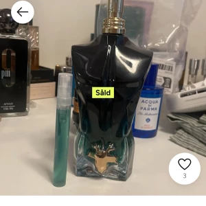 Parfymflaska i form av en manlig torso - En unik parfymflaska formad som en manlig torso i mörkblått glas med gulddetaljer. Flaskan har en elegant och stilren design som gör den till en snygg inredningsdetalj. Perfekt för den som vill ha något annorlunda på parfymhyllan.
