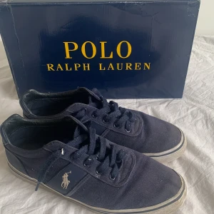mörkblåa sneakers från Polo Ralph Lauren - Snygga mörkblåa sneakers från Polo Ralph Lauren med klassisk design. Ganska andvända därför är priset så lågt. Skick 6-7/10 Orginal pris: 899 kr. Passar också som 44 & 45
