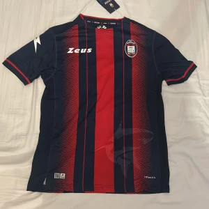 FC Crotone hemma-tröja 18/19 - FC Crotones hemmaställ från säsongen 2018/19. Tröjan är helt ny och har lapparna kvar. Den är köpt från classicfootballshirts.com, och är helt äkta.