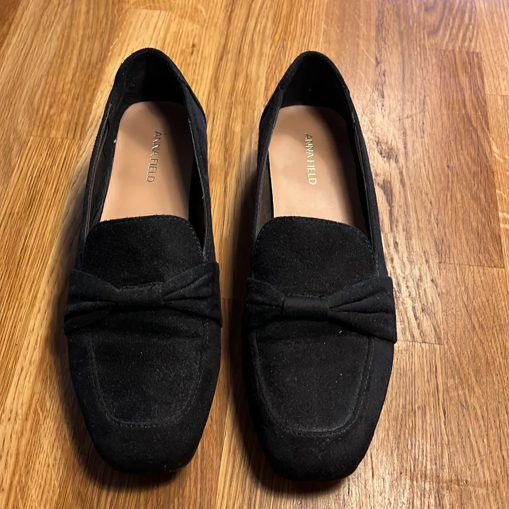Snygga svarta loafers från Anna Field i mocka med en elegant rosett på ovansidan. Perfekta för en stilren look. Skorna har en klassisk design med låg klack och en bekväm passform.. Kengät.