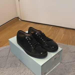 Svarta sneakers från Lanvin - Snygga svarta sneakers från Lanvin med klassisk design och snörning. Skorna har en stilren look och är perfekta för en trendig vardagsstil. Levereras i originalkartong. Kommer med kvitto och är bara lite smutsiga går å fixa och priset kan ändras via snabb affär!!!!