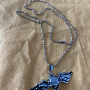Halsband med olika hängen - Säljer flera coola halsband med unika hängen. Ett halsband har ett silverfärgat kors med svarta detaljer och röd sten. Ett annat har ett silverfärgat hänge med en flygande örn. Det tredje halsbandet har ett stilrent hänge i form av en delfin. Alla halsbanden har justerbara kedjor. 125kr/st , helt ny 