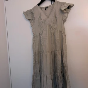 Beige klänning med volangärmar - Säljer en söt beige klänning med volangärmar och v-ringning. Från Vero Moda.