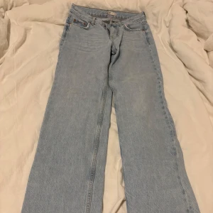 Ljusblå jeansbyxor - Säljer ett par ljusblå jeansbyxor med klassisk femficksdesign. Byxorna har en rak passform och är tillverkade i denim. Perfekta för en avslappnad stil. Sällan använda men fått några fläckar men märks knappt. 