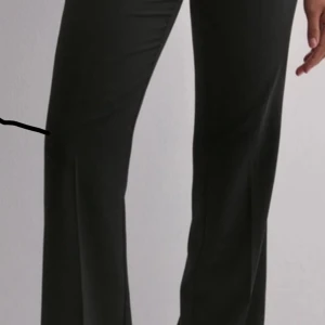 Svarta lågmidjade kostymbyxor - Snygga svarta Lågmidjade kostymbyxor . Perfekta för en chic look och kan enkelt matchas med olika toppar. Byxorna har en elegant passform som ger en modern touch. Aldrig använt 