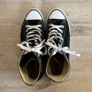 Converse - Svarta höga Converse i storlek 41.5. Använda men fortfarande i väldigt bra skick. Helt nya skosnören medföljer.