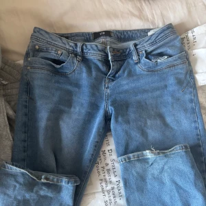 Blå jeans från LTB - Snygga blå jeans från LTB med klassisk femficksdesign och dragkedja. Perfekta för en avslappnad stil. De har en lätt slitning vid knäna som ger en cool look.