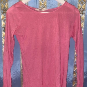 Rosa långärmad tröja från H&M - Säljer en rosa långärmad tröja från H&M:s L.O.G.G. kollektion. Tröjan är i en mjuk och bekväm bomullsmix, perfekt för vardagsbruk. Enkel design med rund halsringning.