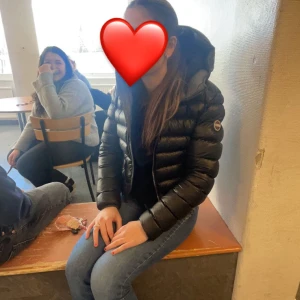 Svart dunjacka från Colmar - Säljer en snygg svart dunjacka från Colmar Jackan har en dragkedja framtill och är perfekt för kyligare väder. Den är långärmad och har en klassisk pufferdesign som håller dig varm och stilren. Som man ser på bilden så är det ett litet hål där men det inget man märker 