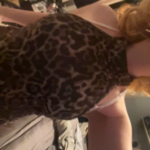 Leopardmönstrad halterneck topp - Snygg leopardmönstrad halterneck topp med hög hals. Perfekt för en trendig look. Toppen är ärmlös och har en tight passform.