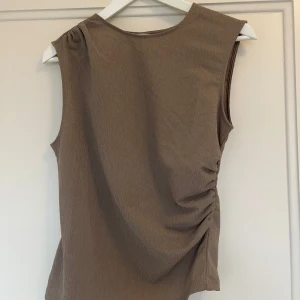 Brun topp - Brun/mörkbeige topp från HM med ”rynkade”. Aldrig använd och prislappen sitter kvar 🤎