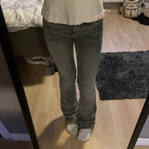 Grå jeans från Gina Tricot - Snygga grå jeans från Gina Tricot med vita sömmar och en klassisk femficksdesign. Byxorna har en rak passform och är perfekta för en avslappnad stil. De är tillverkade i ett bekvämt material som ger en skön känsla hela dagen. St 164 men passar mig som brukar när xs 