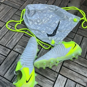 Nike phantom gx II elite ag mad voltage - Ett par väldigt snygga knappt använda fotbollsskor, kanske lite leriga som snabbt går bort om man tvättar dom, påse ingår, pris kan diskuteras, tveka inte på att hör av dig 🤩✨🌟TAR BYTEN