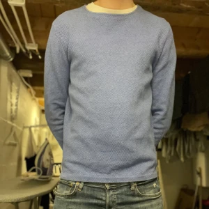 Blå tröja från Massimo Dutti - Säljer en stilren blå tröja från Massimo Dutti i extrafin bomull. Tröjan har en klassisk passform med långa ärmar och rund halsringning. Perfekt för en avslappnad men ändå elegant look.