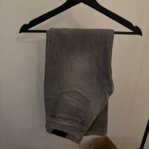 Grå acne jeansbyxor - Snygga grå jeansbyxor med en klassisk design. De har en rak passform och är perfekta för en avslappnad stil. Byxorna har fickor både fram och bak samt en dragkedja. Perfekta för alla årstider.